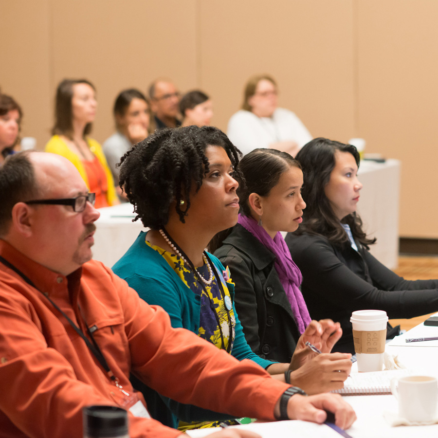 Photo of attendees from the 2014 conference, watching a session in progress.